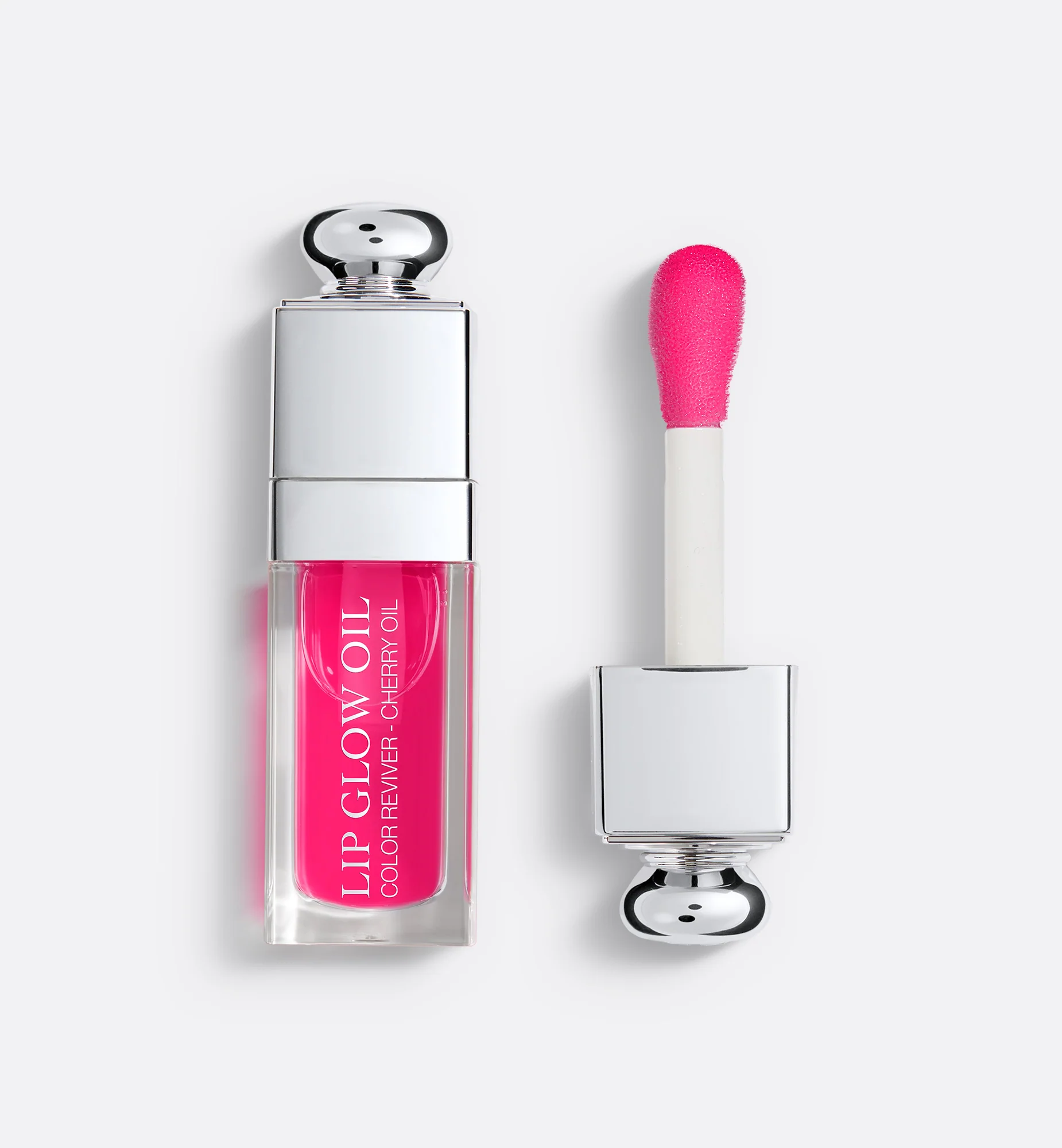 A clear lip oil tube with a red cherry-like tint.
